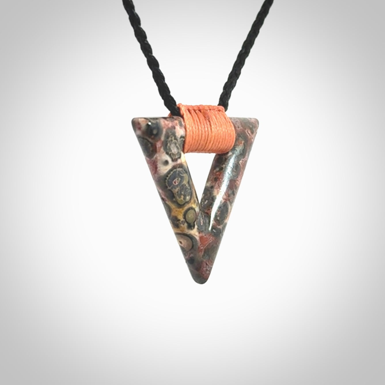 This is a hand carved triangle pendant made from a gorgeous and striking piece of Tiger Jasper. This is a hand carved and very unique necklace. For sale online from NZ Pacific. Delivered with adjustable cord.