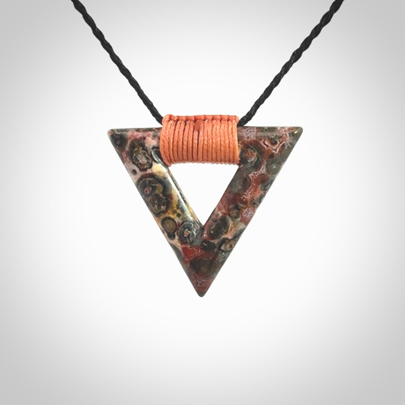 This is a hand carved triangle pendant made from a gorgeous and striking piece of Tiger Jasper. This is a hand carved and very unique necklace. For sale online from NZ Pacific. Delivered with adjustable cord.