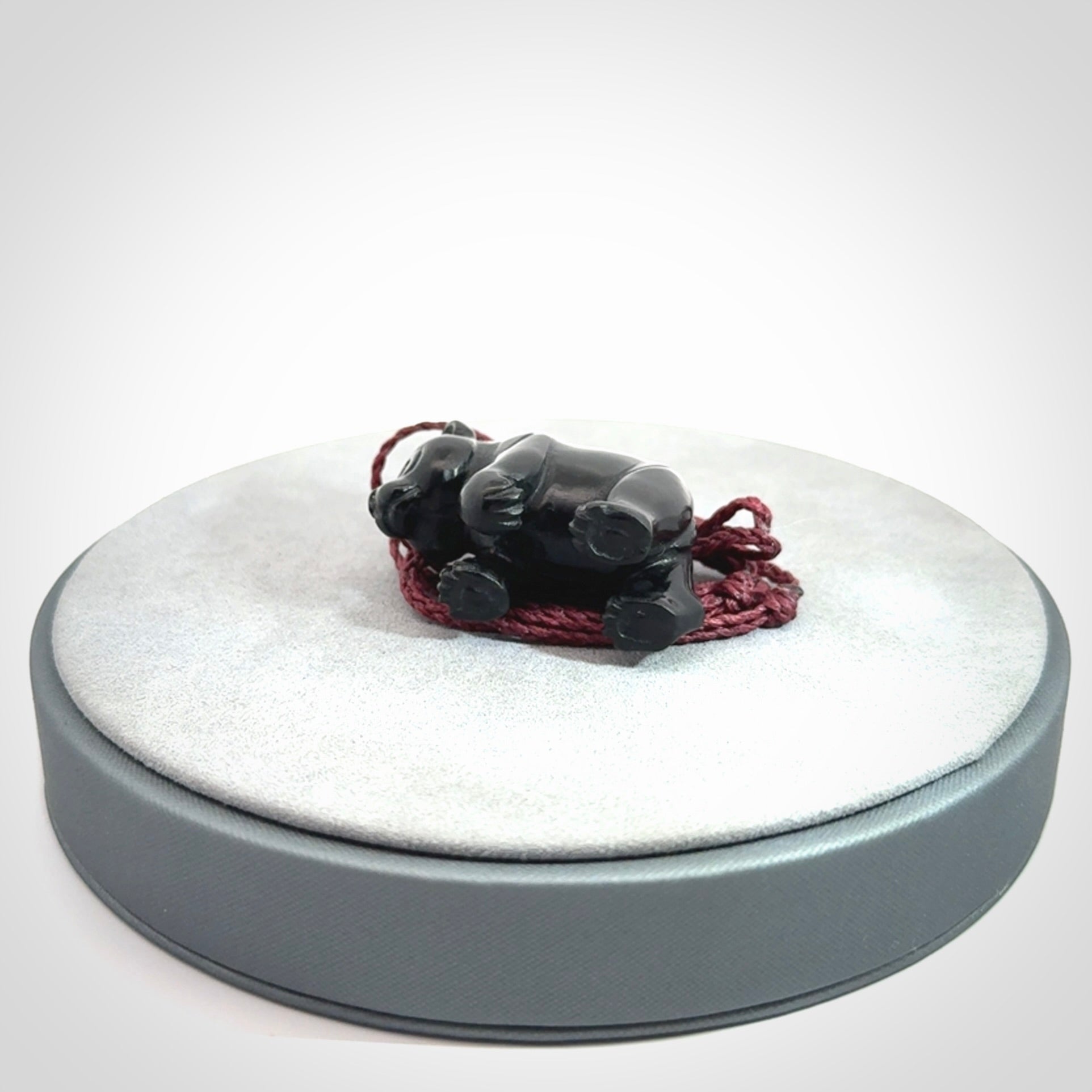 This picture shows a pendant that we designed in black jade. It is a little black bear that has a walking stance and is carved in detail. A really attractive and eye-catching piece of handmade jewellery. The cord is burgundy and the length can be adjusted.