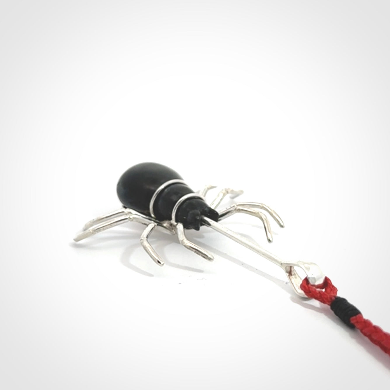 Hand crafted black jade and sterling silver spider necklace. This necklace is provided with a red adjustable cord. Contemporary black jade spider necklace with sterling silver. Delivered with express courier and packaged in a woven kete pouch.