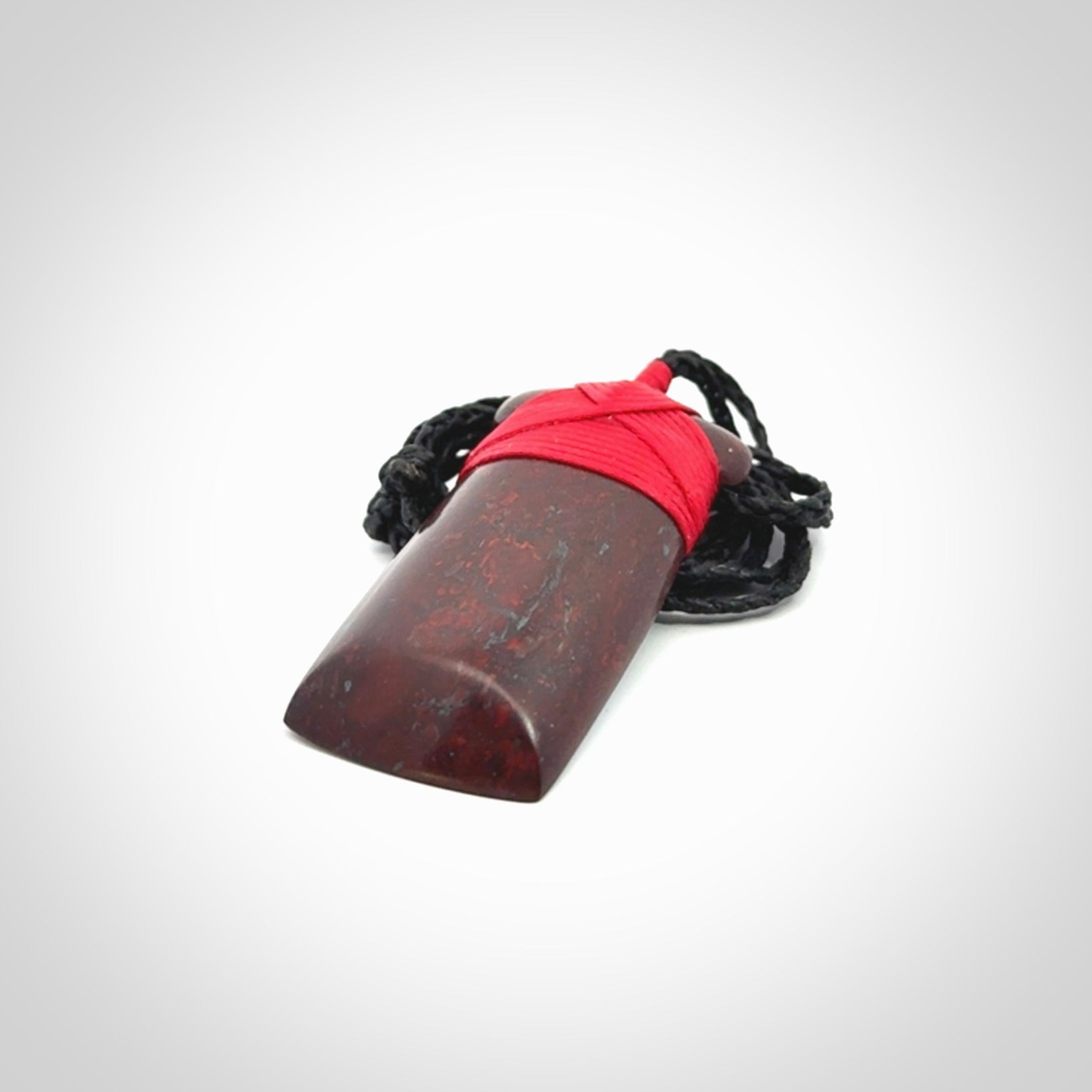 This is a beautiful hand carved Red Jasper Stone toki pendant. A really cool piece that is made from this rare and beautiful material. The red jasper has a very distinctive look and each piece is different. We ship this worldwide and the cost of shipping is included in the price. Provided with adjustable cords and packaged in a woven kete pouch.
