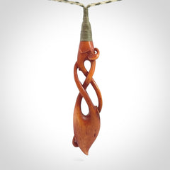 This pendant is carved from cow bone and stained with a homemade tea dye. It is a unique piece of wearable art that is sure to catch the eye. The shape is a complex twist form and has been beautifully hand carved by bone carver Yuri Terenyi.