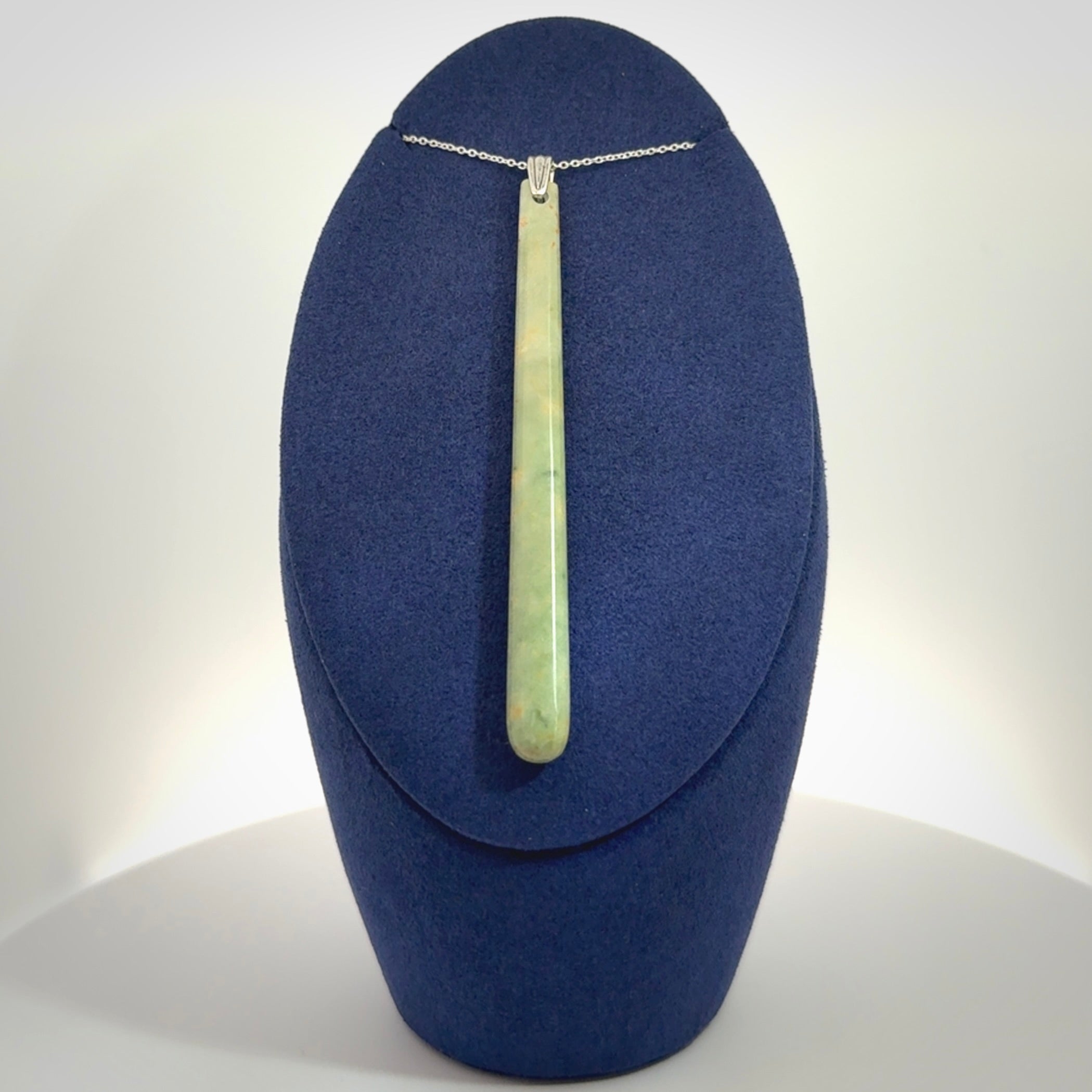 A hand carved New Zealand Jade Drop pendant with sterling silver clasp and chain.