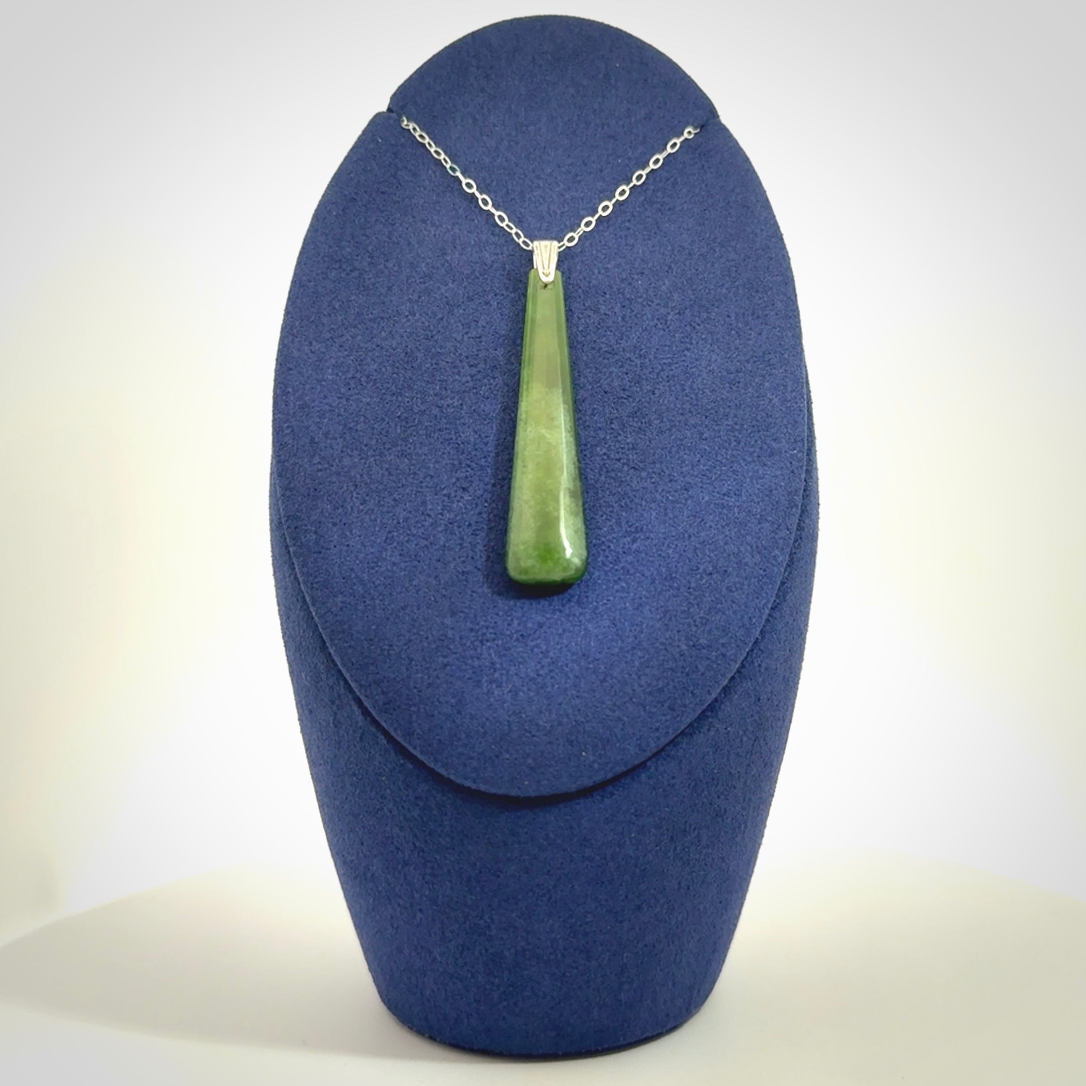 A hand carved New Zealand Jade Drop pendant with sterling silver clasp and chain.