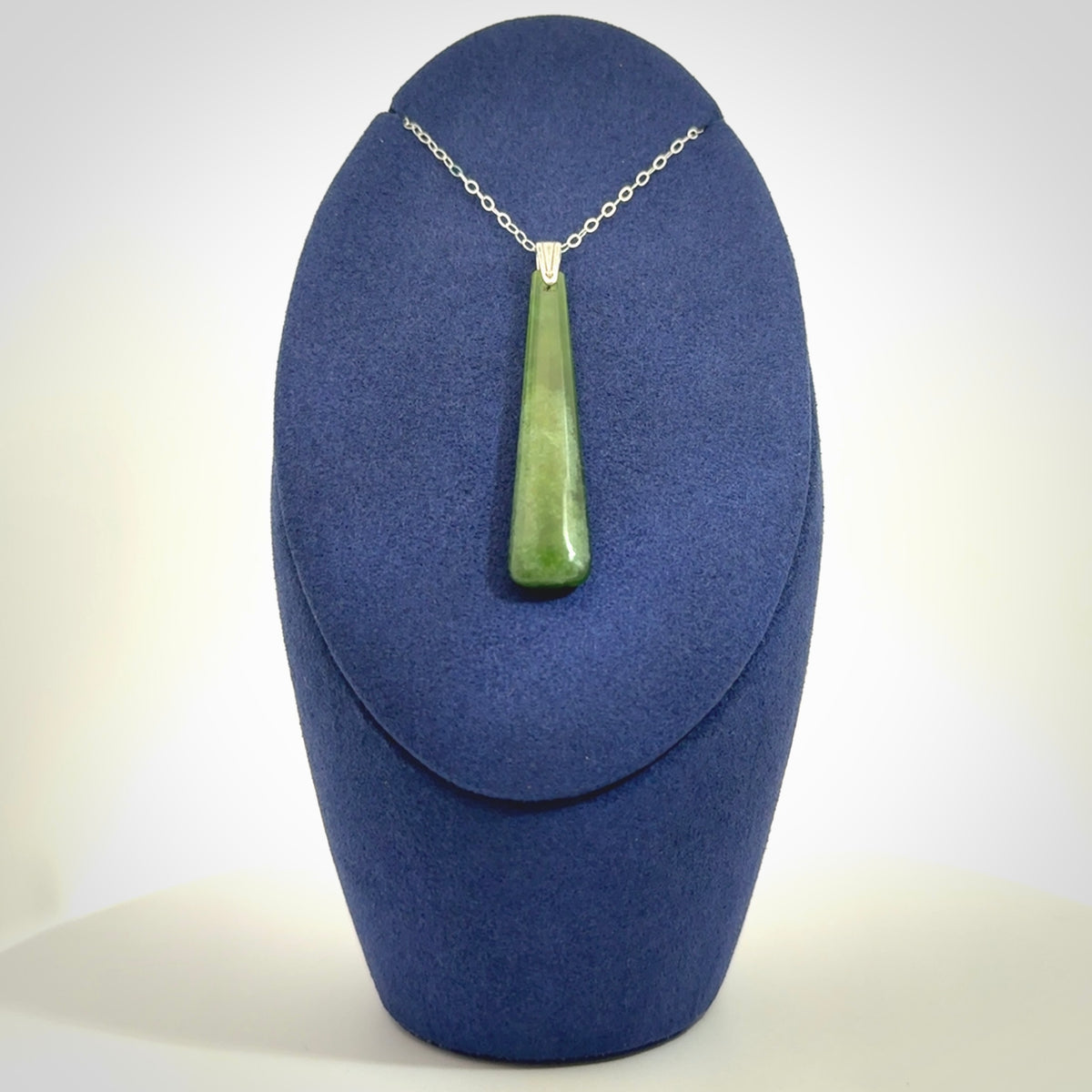 A hand carved New Zealand Jade Drop pendant with sterling silver clasp and chain.