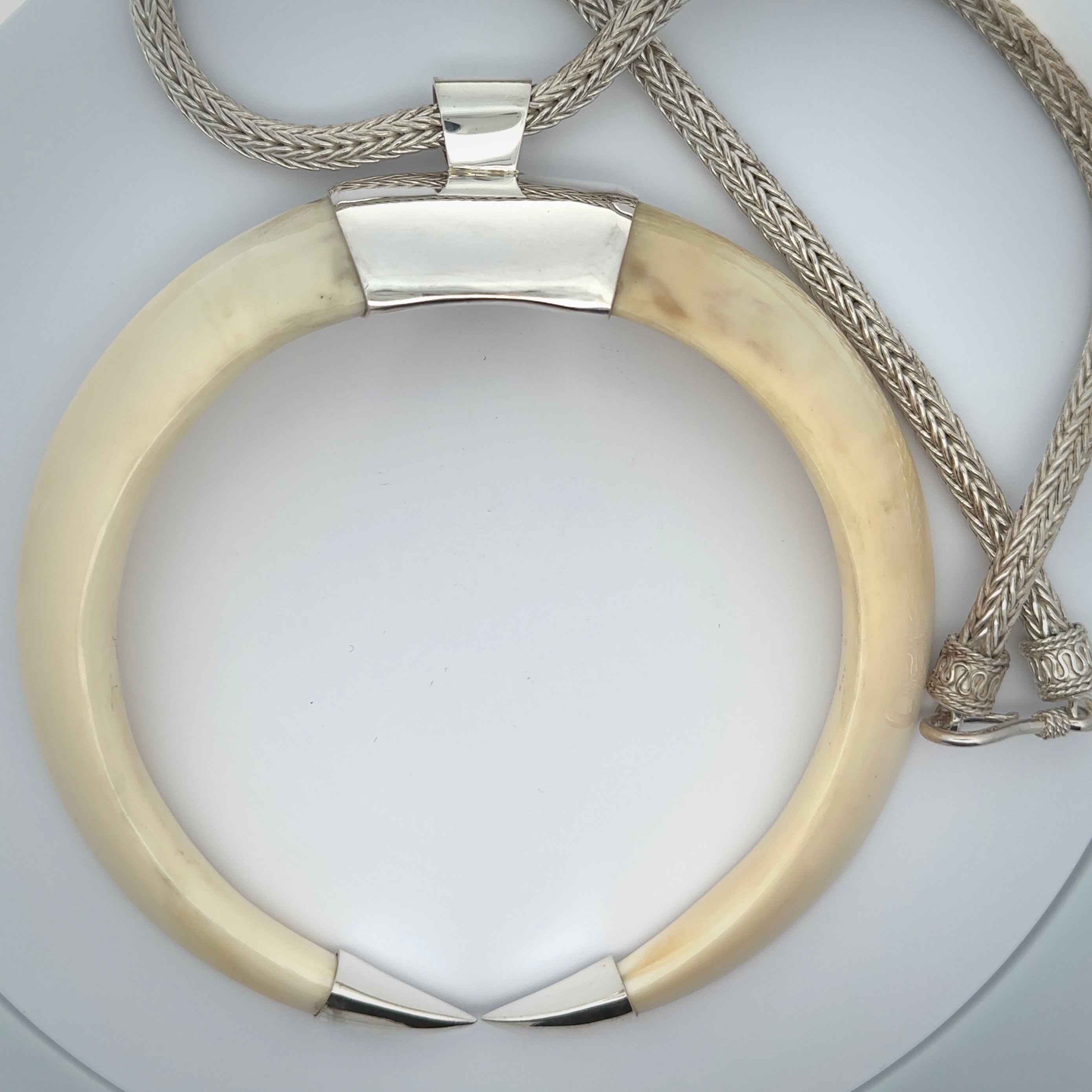 Boars Tusk Pendant with a sterling silver cap. Hand made pendant carved from a boars tusk. Hand made unique jewellery for sale by NZ Pacific online.