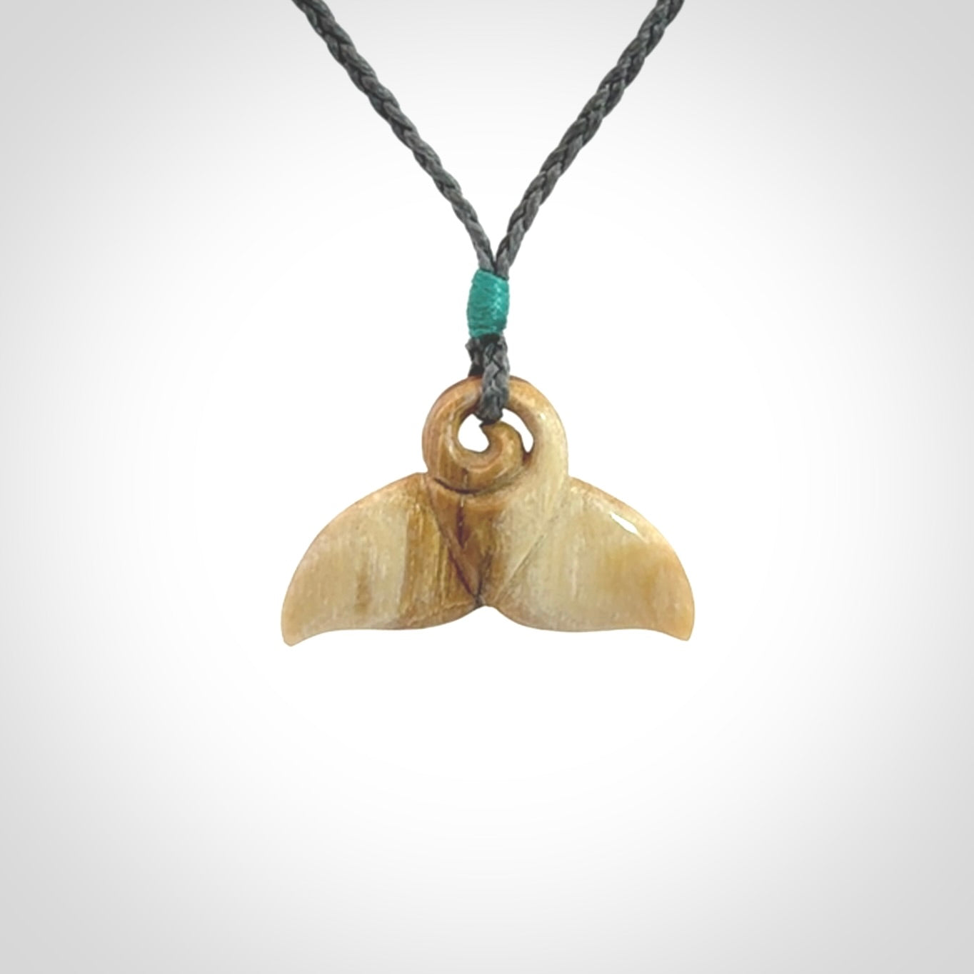 This photo shows a small whaletail pendant that we have carved from a light honey coloured piece of Woolly Mammoth tusk. It is suspended on a an adjustable cord.