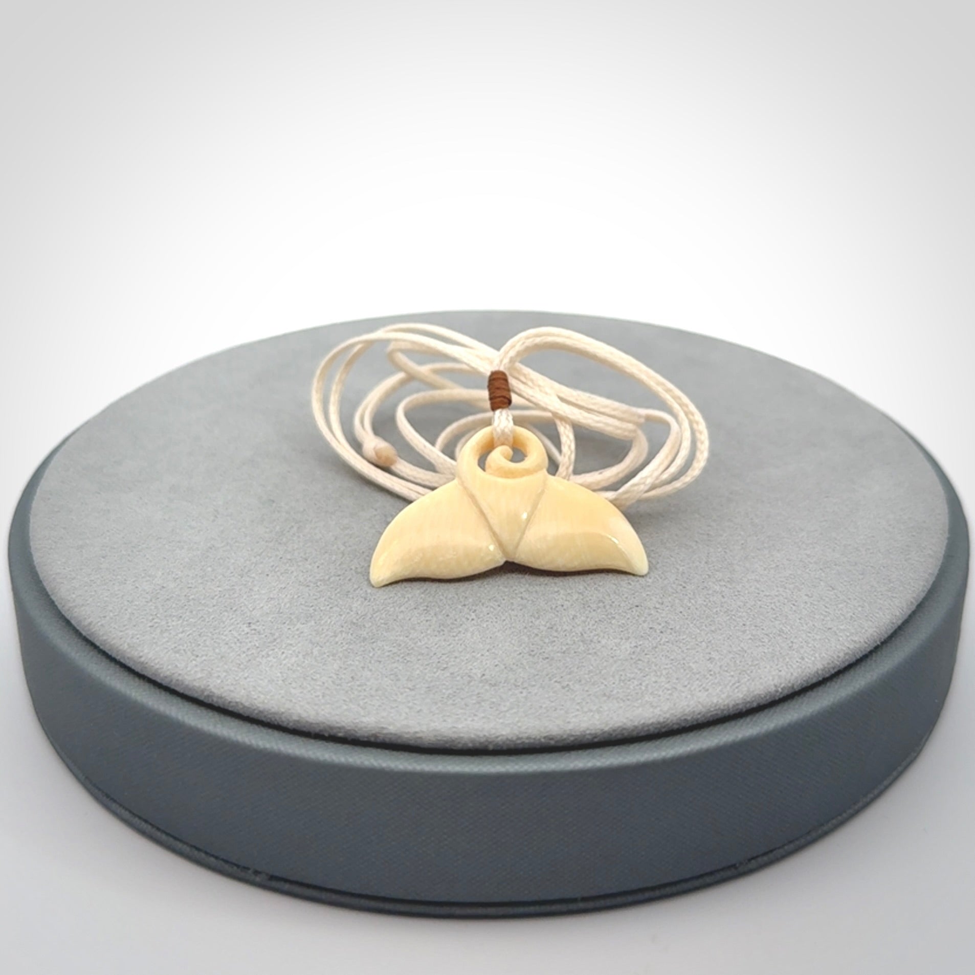 This photo shows a small whaletail pendant that we have carved from a light honey coloured piece of Woolly Mammoth tusk. It is suspended on a an adjustable cord.
