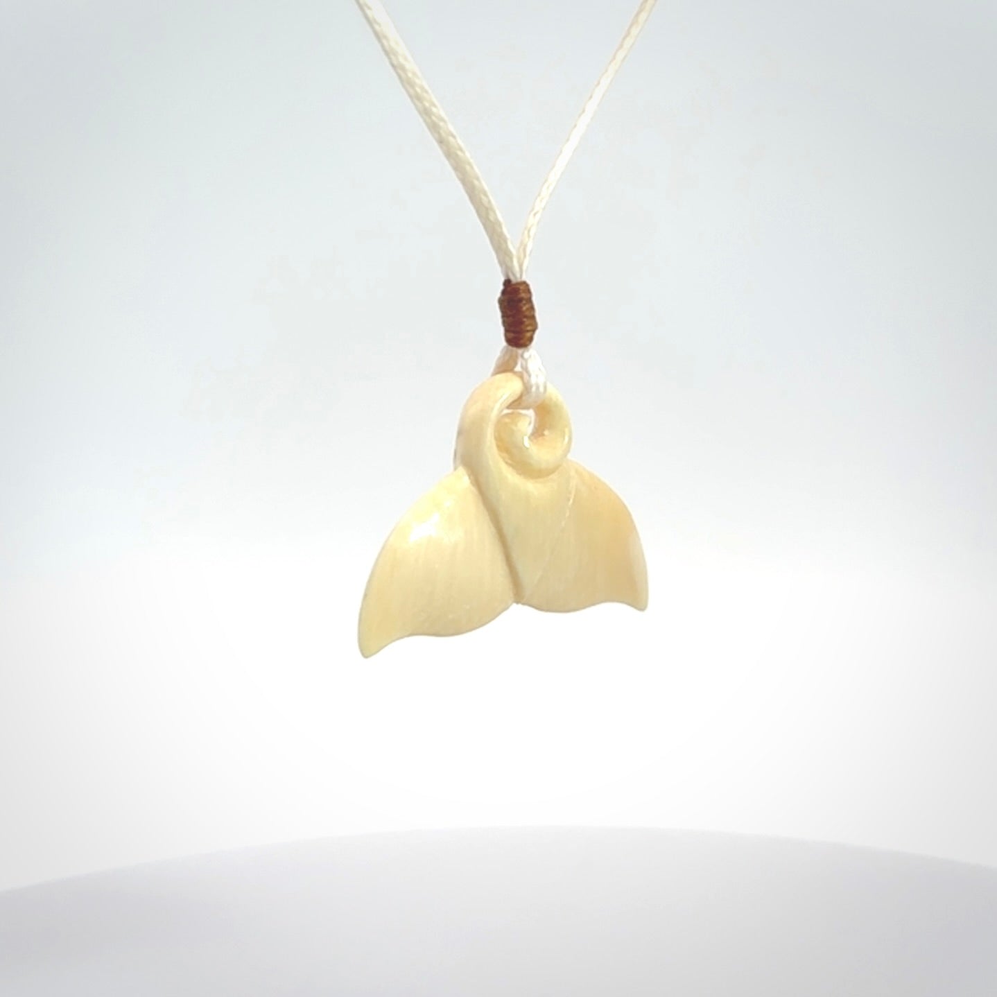 This photo shows a small whaletail pendant that we have carved from a light honey coloured piece of Woolly Mammoth tusk. It is suspended on a an adjustable cord.