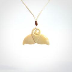 This photo shows a small whaletail pendant that we have carved from a light honey coloured piece of Woolly Mammoth tusk. It is suspended on a an adjustable cord.