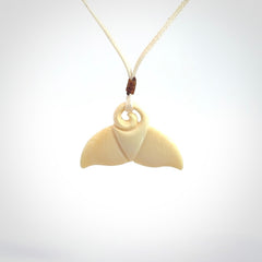 This photo shows a small whaletail pendant that we have carved from a light honey coloured piece of Woolly Mammoth tusk. It is suspended on a an adjustable cord.