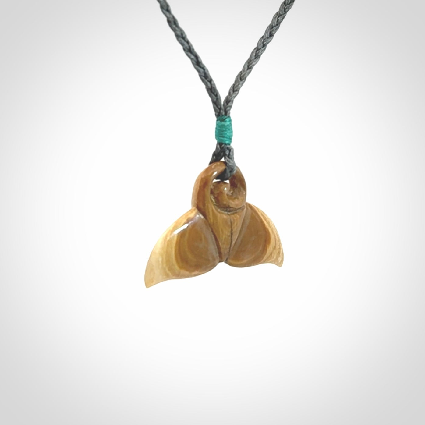 This photo shows a small whaletail pendant that we have carved from a light honey coloured piece of Woolly Mammoth tusk. It is suspended on a an adjustable cord.
