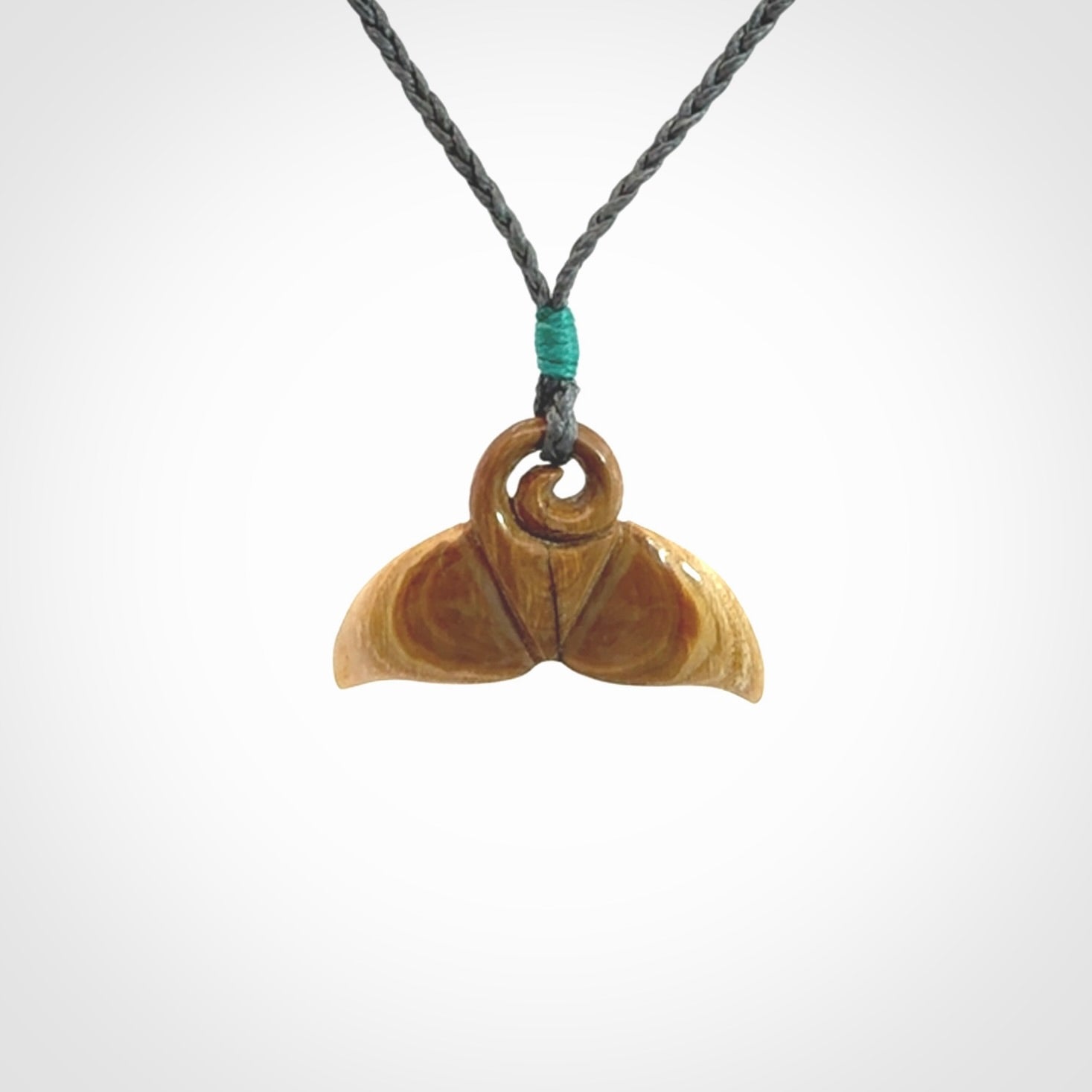 This photo shows a small whaletail pendant that we have carved from a light honey coloured piece of Woolly Mammoth tusk. It is suspended on a an adjustable cord.