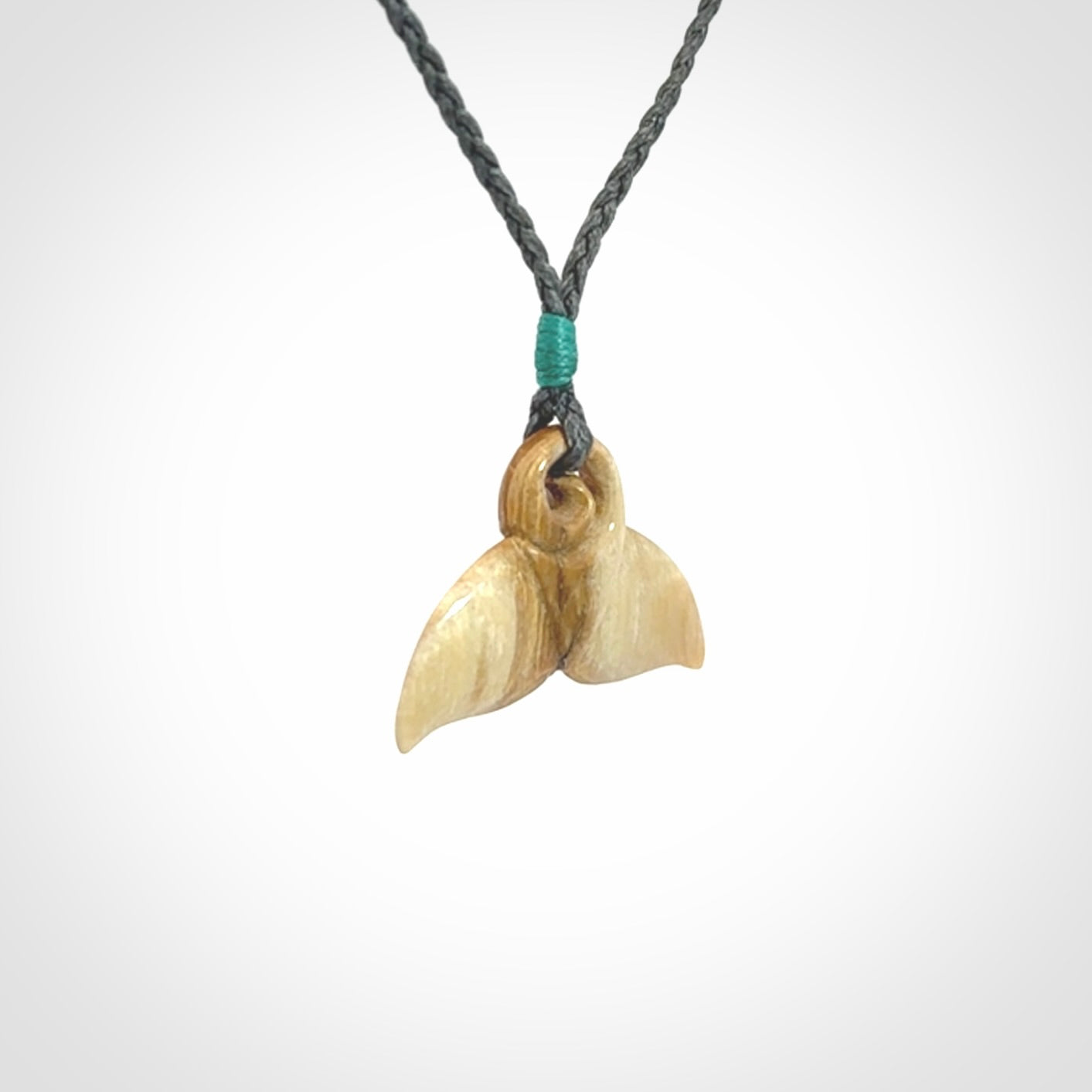 This photo shows a small whaletail pendant that we have carved from a light honey coloured piece of Woolly Mammoth tusk. It is suspended on a an adjustable cord.