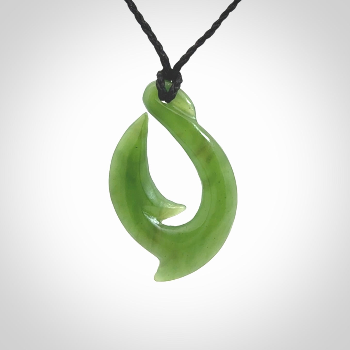 Hand made New Zealand Kahurangi Jade, hook, hei-matau pendant. Hand carved fish hook made from New Zealand jade. Carved by Ross Crump. Provided with adjustable black cord.