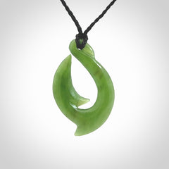 Hand made New Zealand Kahurangi Jade, hook, hei-matau pendant. Hand carved fish hook made from New Zealand jade. Carved by Ross Crump. Provided with adjustable black cord.