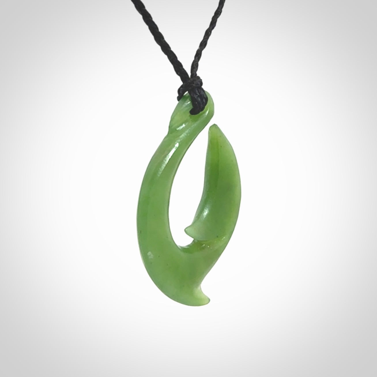 Hand made New Zealand Kahurangi Jade, hook, hei-matau pendant. Hand carved fish hook made from New Zealand jade. Carved by Ross Crump. Provided with adjustable black cord.