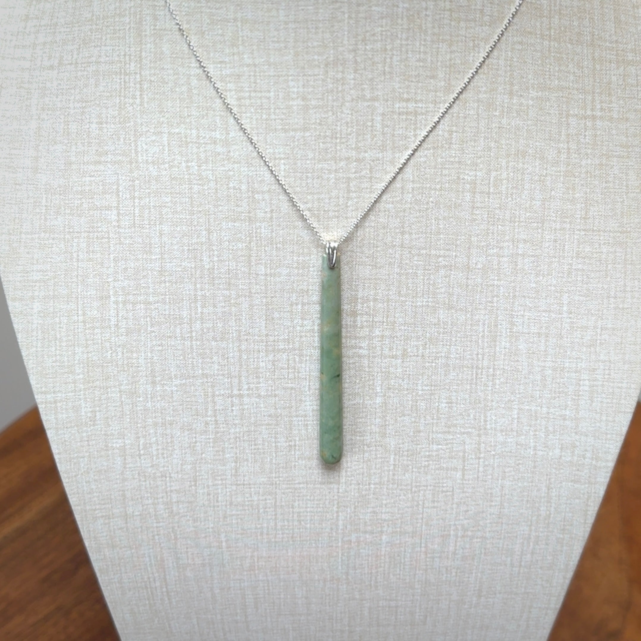 A hand carved New Zealand Jade Drop pendant with sterling silver clasp and chain.