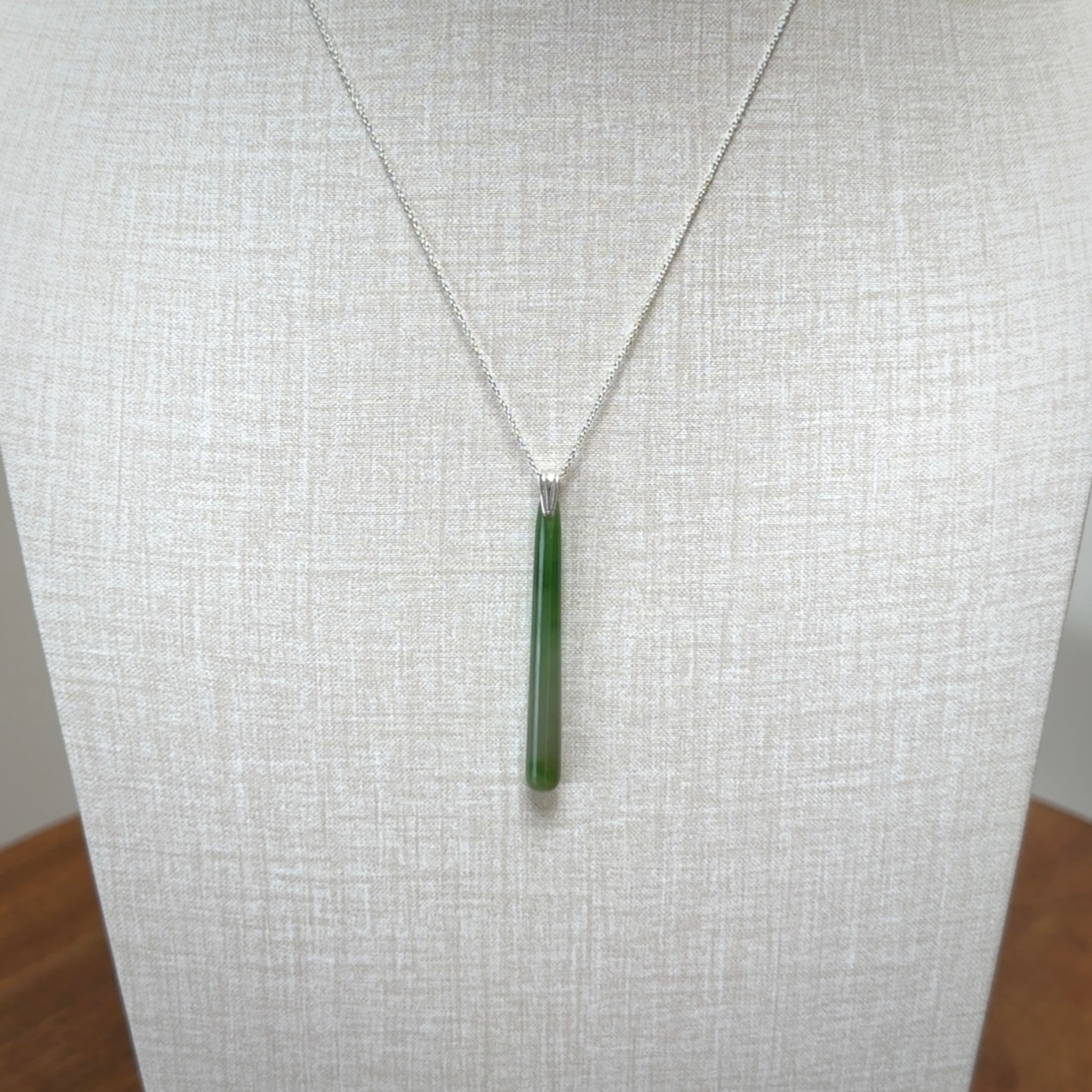 A hand carved New Zealand Jade Drop pendant with sterling silver clasp and chain.