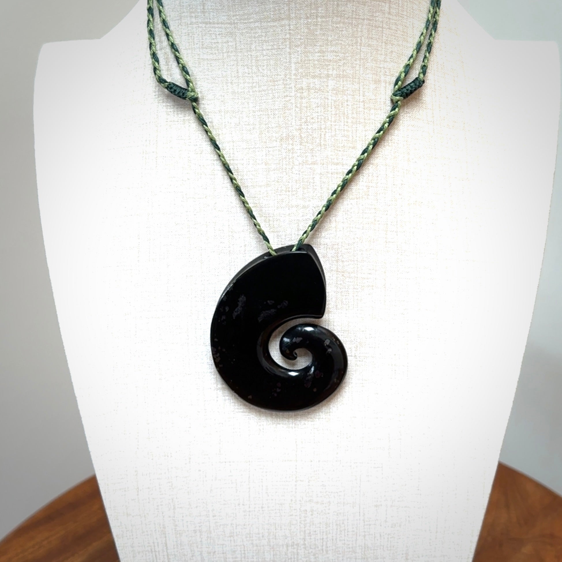 A hand carved koru pendant from New Zealand Tangiwai Pounamu. The cord is a Fern/Manuka Green colour and is an adjustable length. A large hand made Koru necklace by New Zealand artist Kerry Thompson.