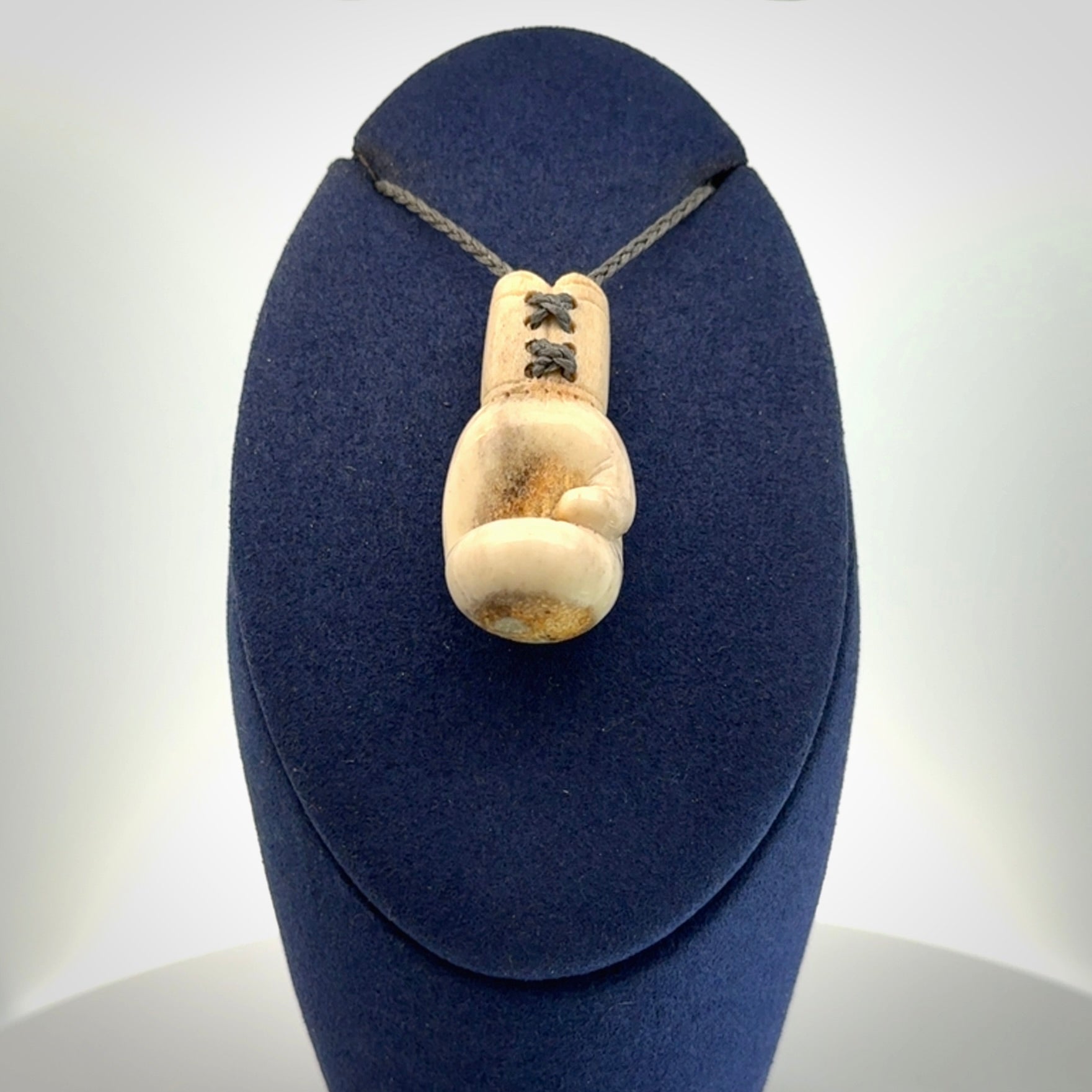 Hand carved boxing glove made from deer antler. The cord is adjustable so that you can wear this where it suits you best.