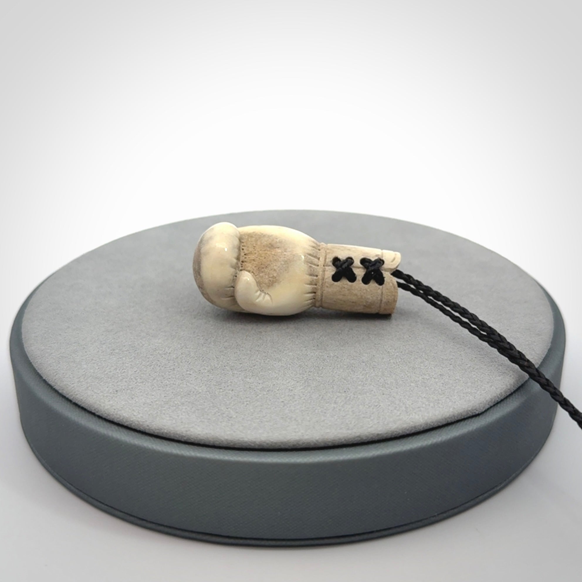Hand carved boxing glove made from deer antler. The cord is adjustable so that you can wear this where it suits you best.