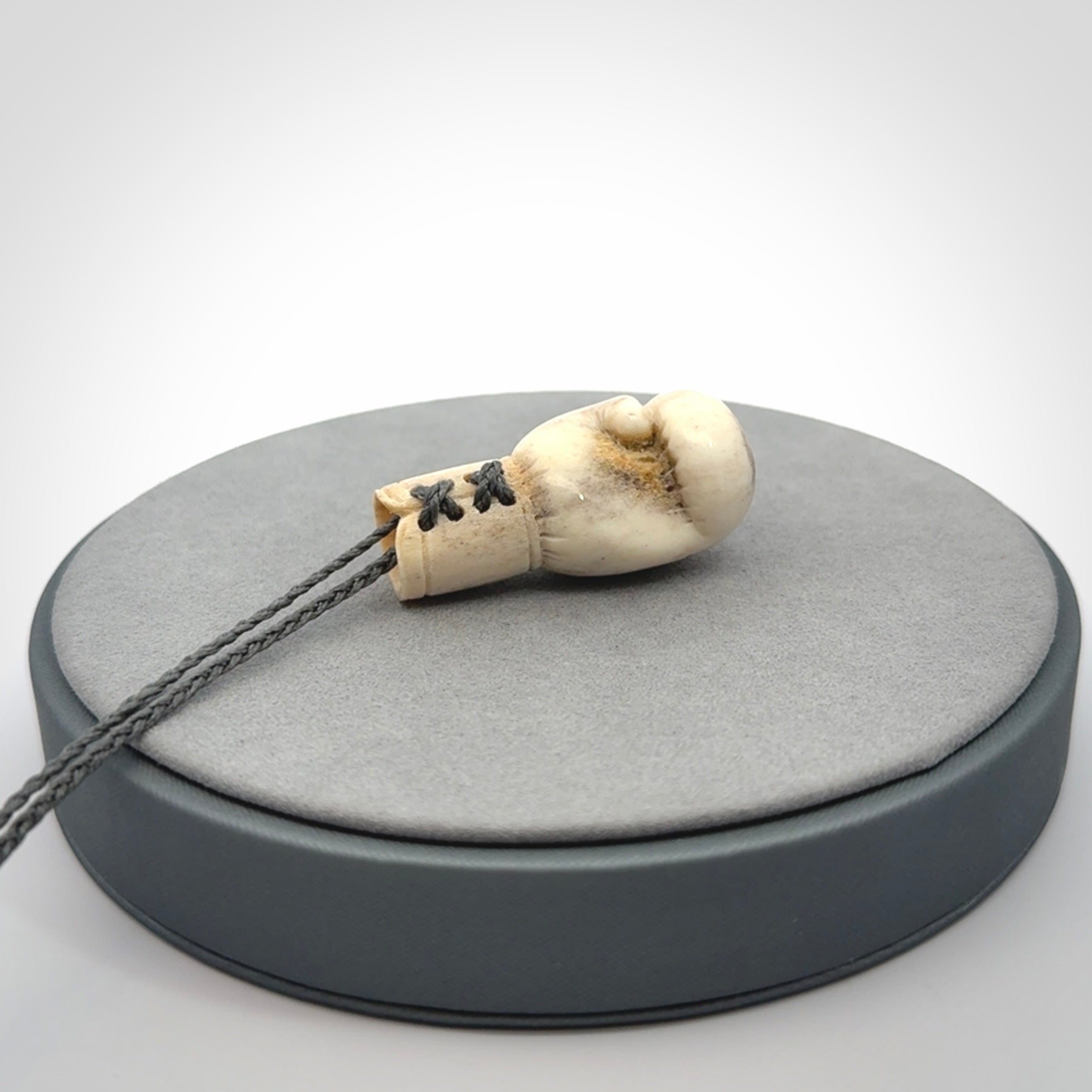 Hand carved boxing glove made from deer antler. The cord is adjustable so that you can wear this where it suits you best.