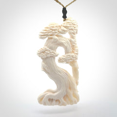 This is a beautiful hand carved tree pendant. It is a wonderfully detailed pendant that we have carved in natural, untreated bone. We provide this with a tan coloured adjustable cord and shipping is included worldwide.