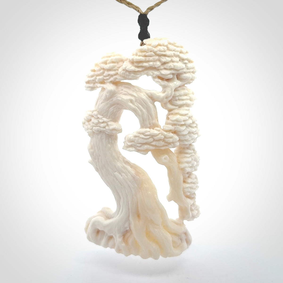 This is a beautiful hand carved tree pendant. It is a wonderfully detailed pendant that we have carved in natural, untreated bone. We provide this with a tan coloured adjustable cord and shipping is included worldwide.