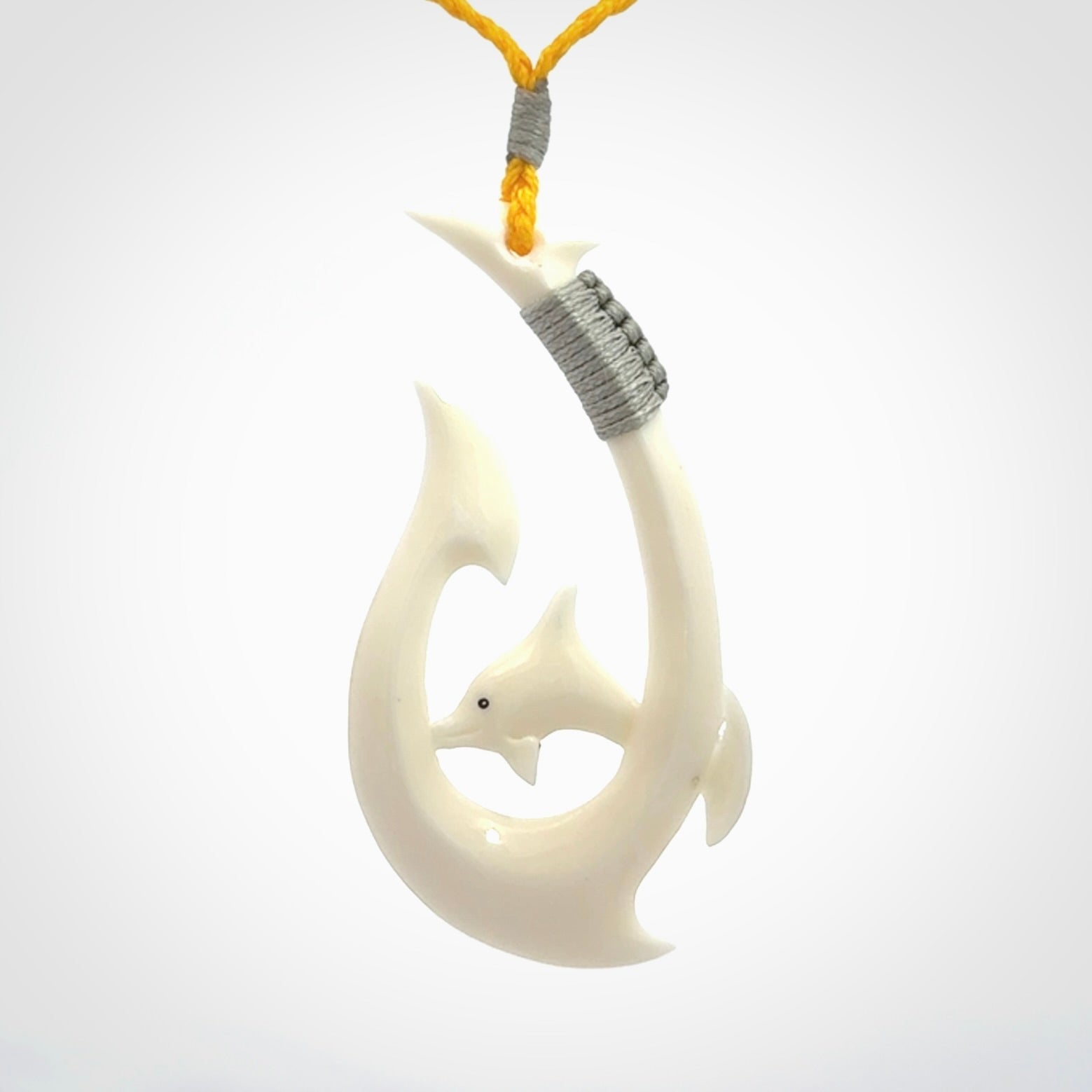 Hand carved bone hook with dolphin pendant. This is a marine-themed pendant which we have made for dolphin lovers and for those of us that love the sea. This piece is handcarved from natural bone and is shipped worldwide free.