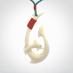 Hand carved bone hook with dolphin pendant. This is a marine-themed pendant which we have made for dolphin lovers and for those of us that love the sea. This piece is handcarved from natural bone and is shipped worldwide free.