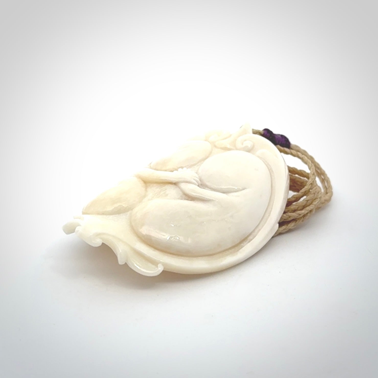 This is a contemporary large pendant carved in bone. Hand carved and provided with an adjustable cord. Twins in womb pendant.