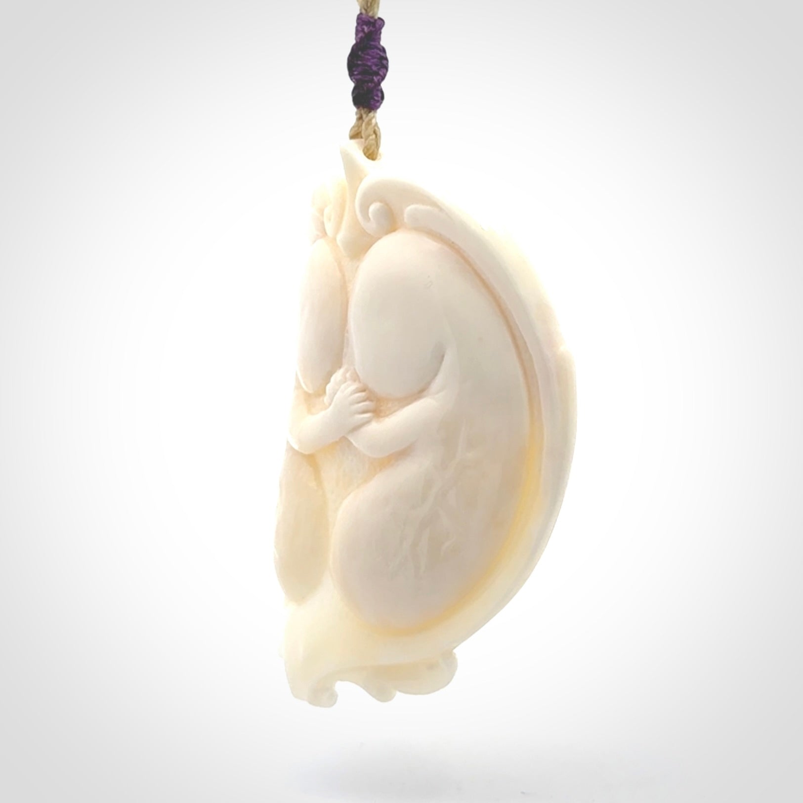 This is a contemporary large pendant carved in bone. Hand carved and provided with an adjustable cord. Twins in womb pendant.