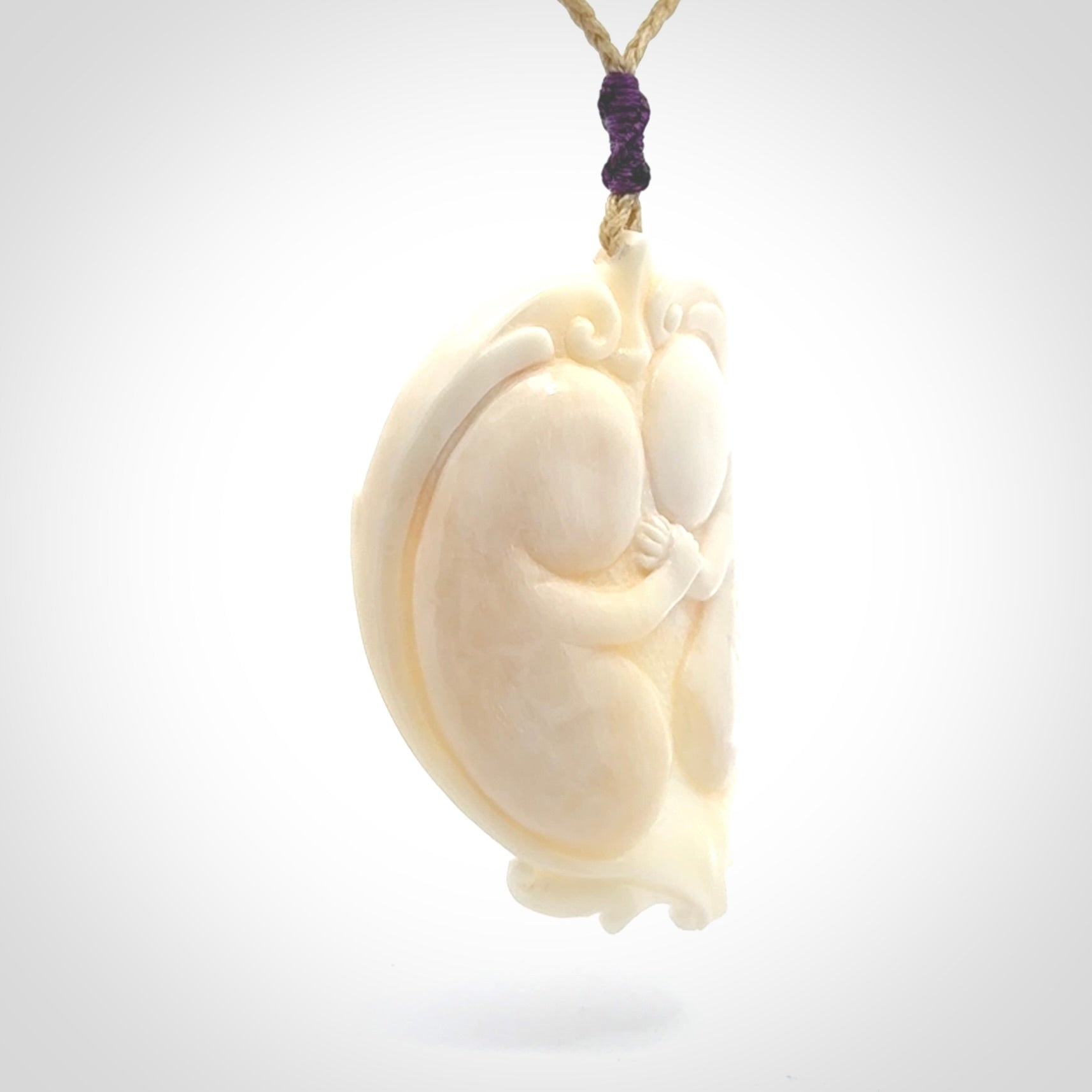 This is a contemporary large pendant carved in bone. Hand carved and provided with an adjustable cord. Twins in womb pendant.