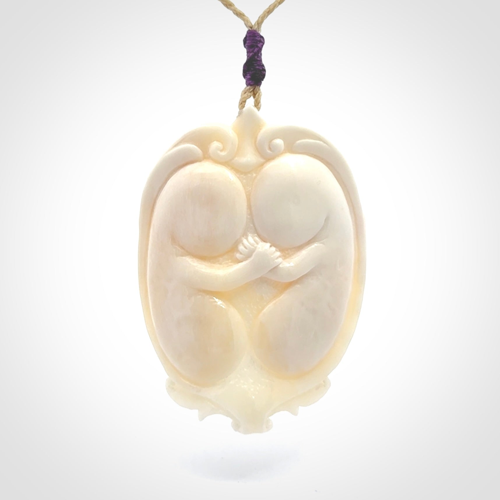 This is a contemporary large pendant carved in bone. Hand carved and provided with an adjustable cord. Twins in womb pendant.