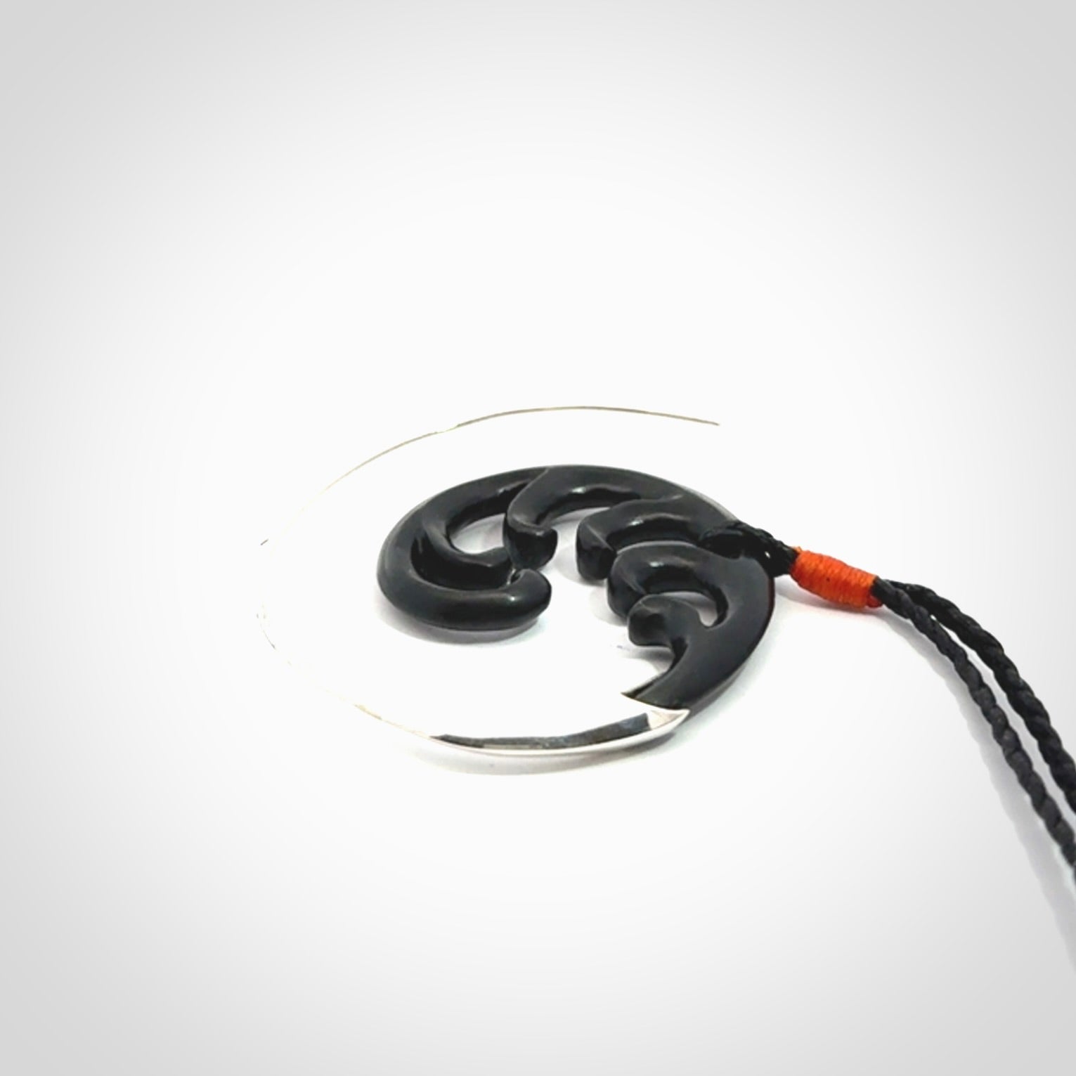 Hand carved pendant made from black jade with sterling silver. NZ Pacific contemporary Koru pendant for sale online.