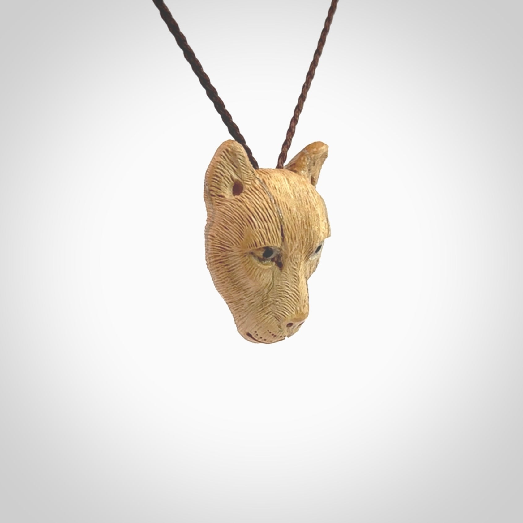 This pendant is a hand carved puma. We've carved this from a lovely piece of woolly mammoth tusk and we provide it with a hand plaited cord. Shipping is free worldwide.