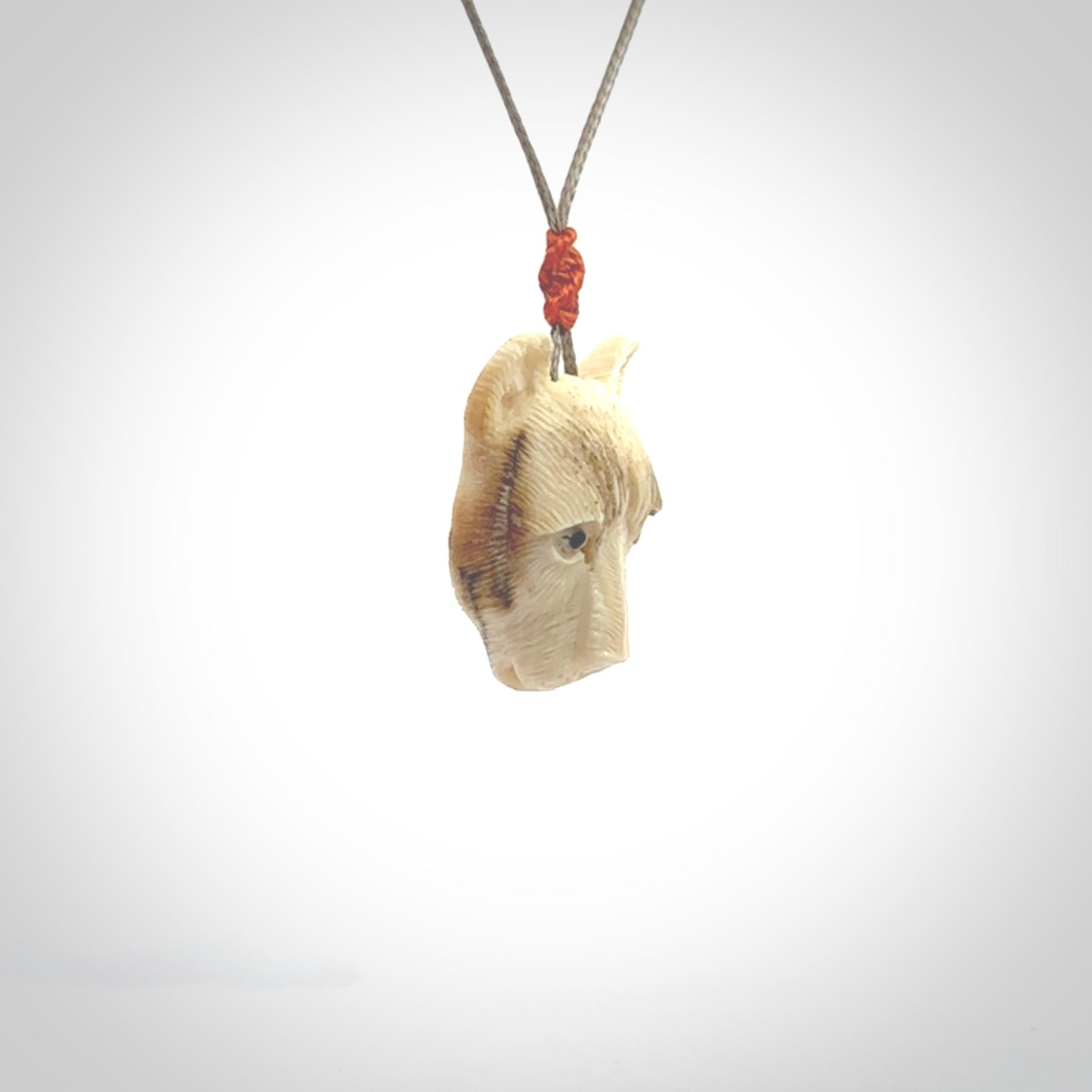 This pendant is a hand carved puma. We've carved this from a lovely piece of woolly mammoth tusk and we provide it with a hand plaited cord. Shipping is free worldwide.
