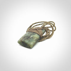 Hand carved from a lovely piece of local New Zealand Jade. We have suspended this from a 3-plait khaki cord which can be adjusted with a couple of slip knots and olive green binding.