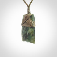 Hand carved from a lovely piece of local New Zealand Jade. We have suspended this from a 3-plait khaki cord which can be adjusted with a couple of slip knots and olive green binding.