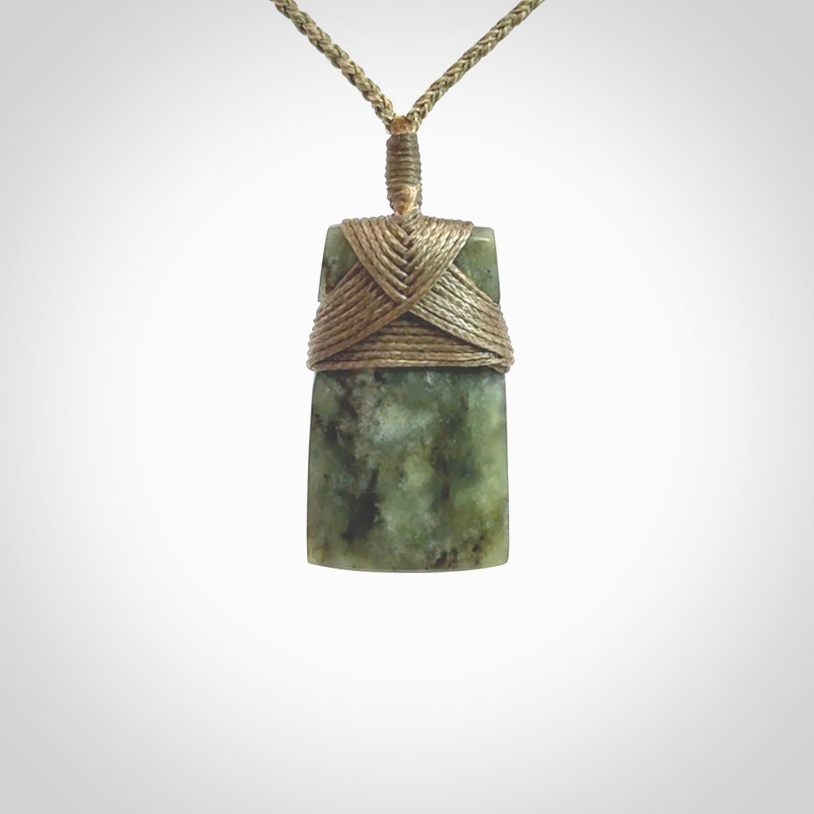 Hand carved from a lovely piece of local New Zealand Jade. We have suspended this from a 3-plait khaki cord which can be adjusted with a couple of slip knots and olive green binding.