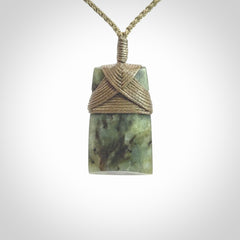 Hand carved from a lovely piece of local New Zealand Jade. We have suspended this from a 3-plait khaki cord which can be adjusted with a couple of slip knots and olive green binding.