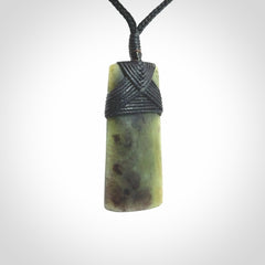 Hand carved from a lovely piece of local New Zealand Jade. We have suspended this from a black cord which can be adjusted with a couple of slip knots and black binding.