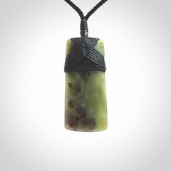Hand carved from a lovely piece of local New Zealand Jade. We have suspended this from a black cord which can be adjusted with a couple of slip knots and black binding.