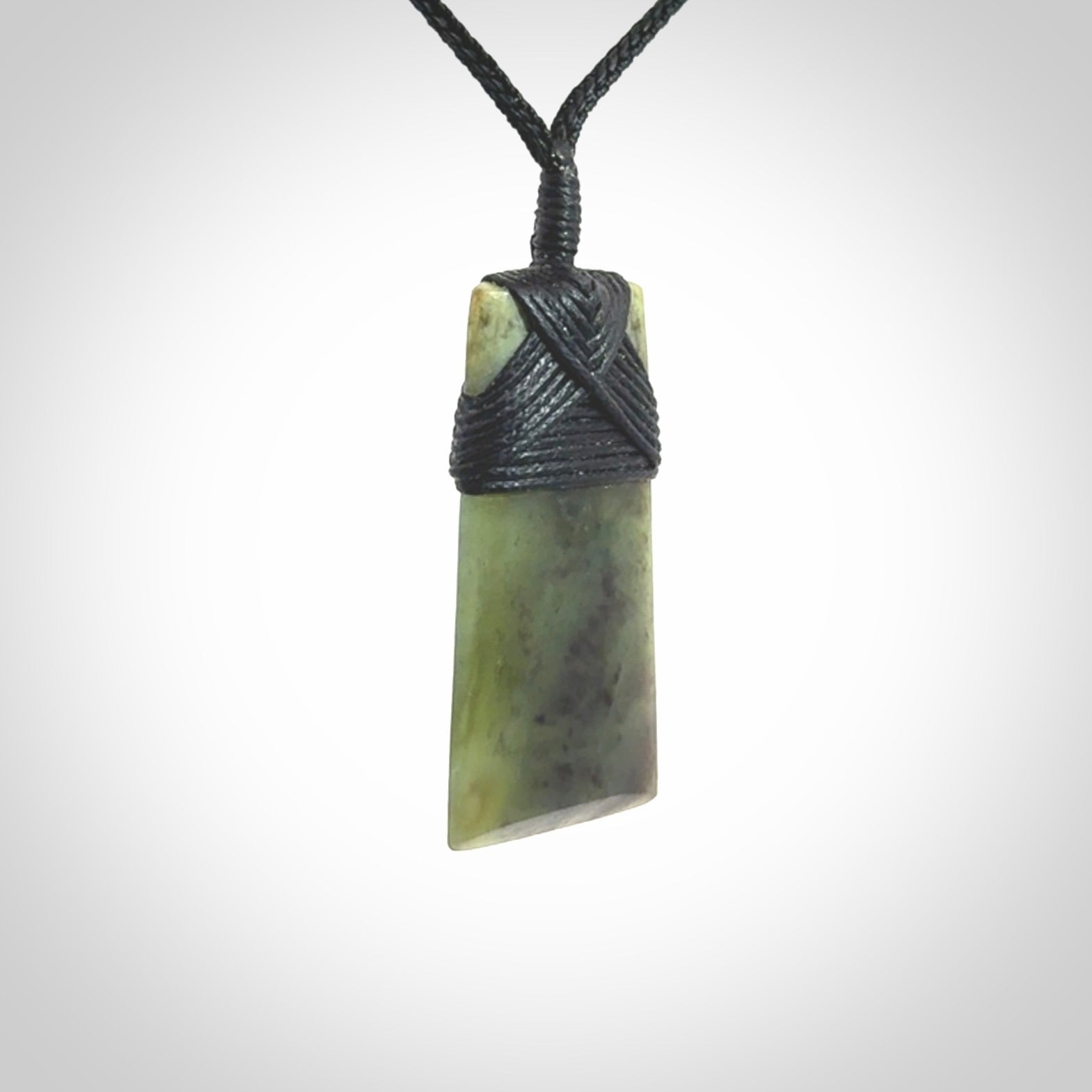 Hand carved from a lovely piece of local New Zealand Jade. We have suspended this from a black cord which can be adjusted with a couple of slip knots and black binding.