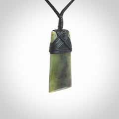 Hand carved from a lovely piece of local New Zealand Jade. We have suspended this from a black cord which can be adjusted with a couple of slip knots and black binding.