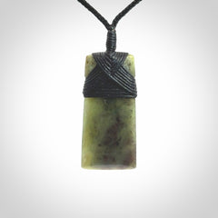 Hand carved from a lovely piece of local New Zealand Jade. We have suspended this from a black cord which can be adjusted with a couple of slip knots and black binding.