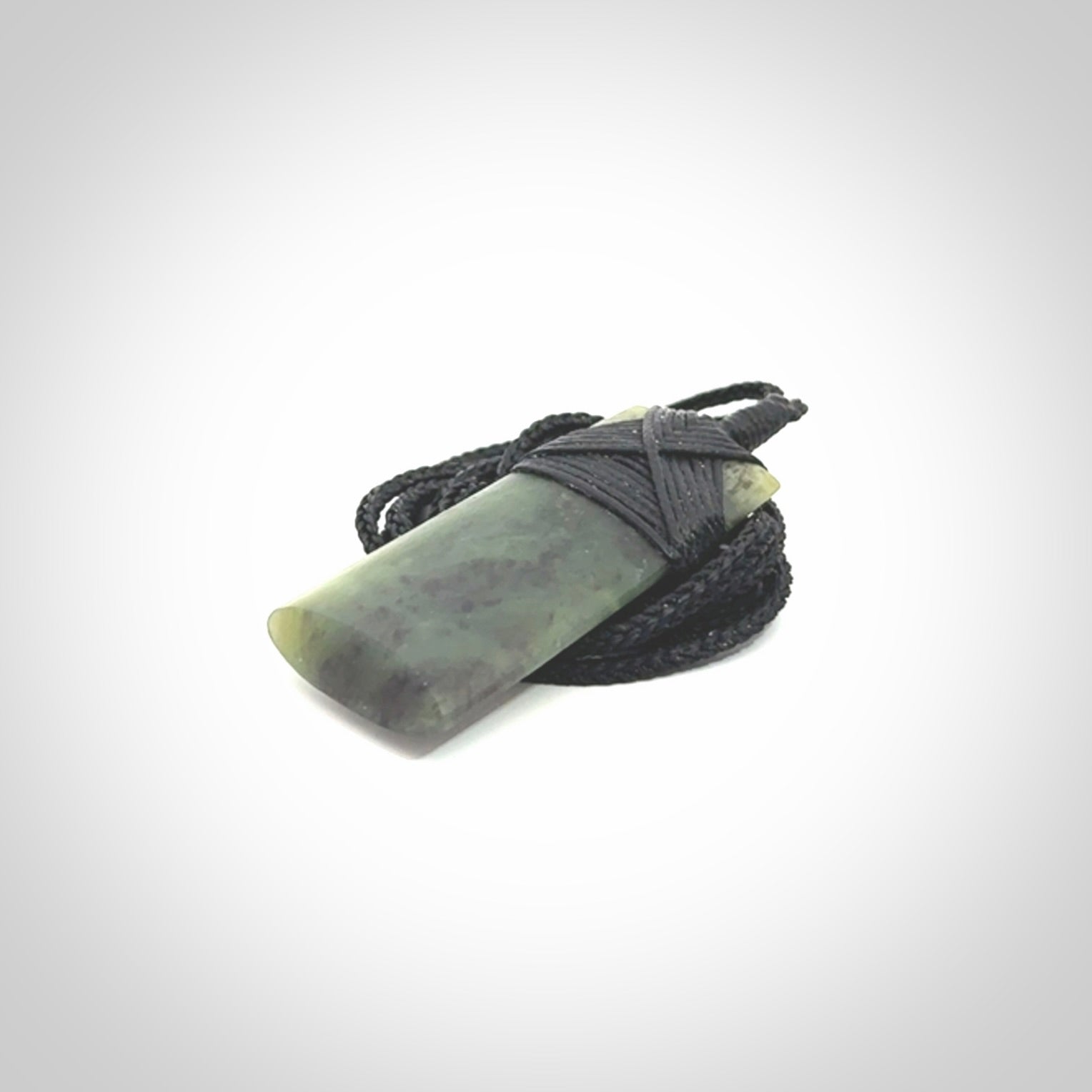 Hand carved from a lovely piece of local New Zealand Jade. We have suspended this from a black cord which can be adjusted with a couple of slip knots and black binding.