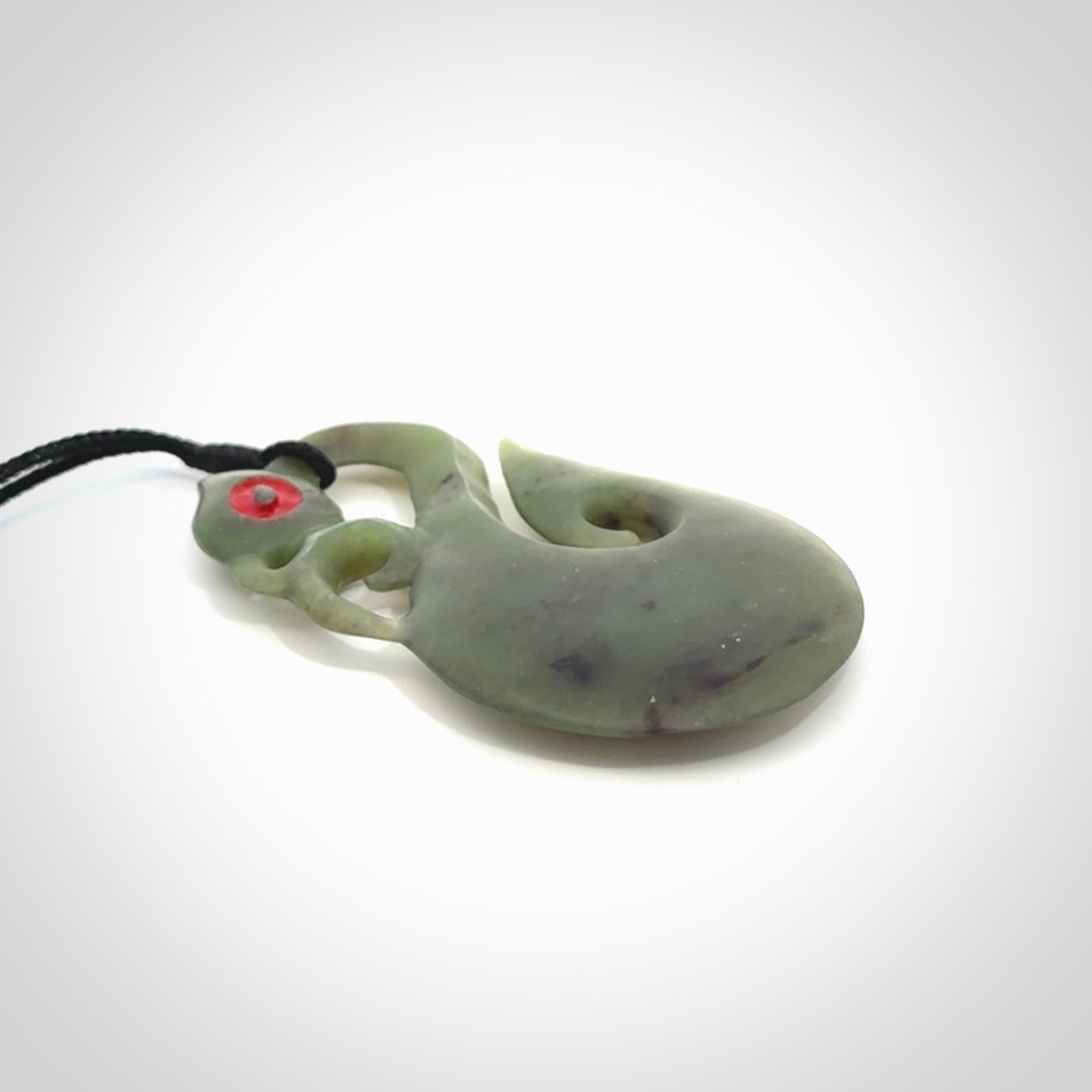This picture shows a traditional manaia with hook pendant carved in New Zealand Jade.
