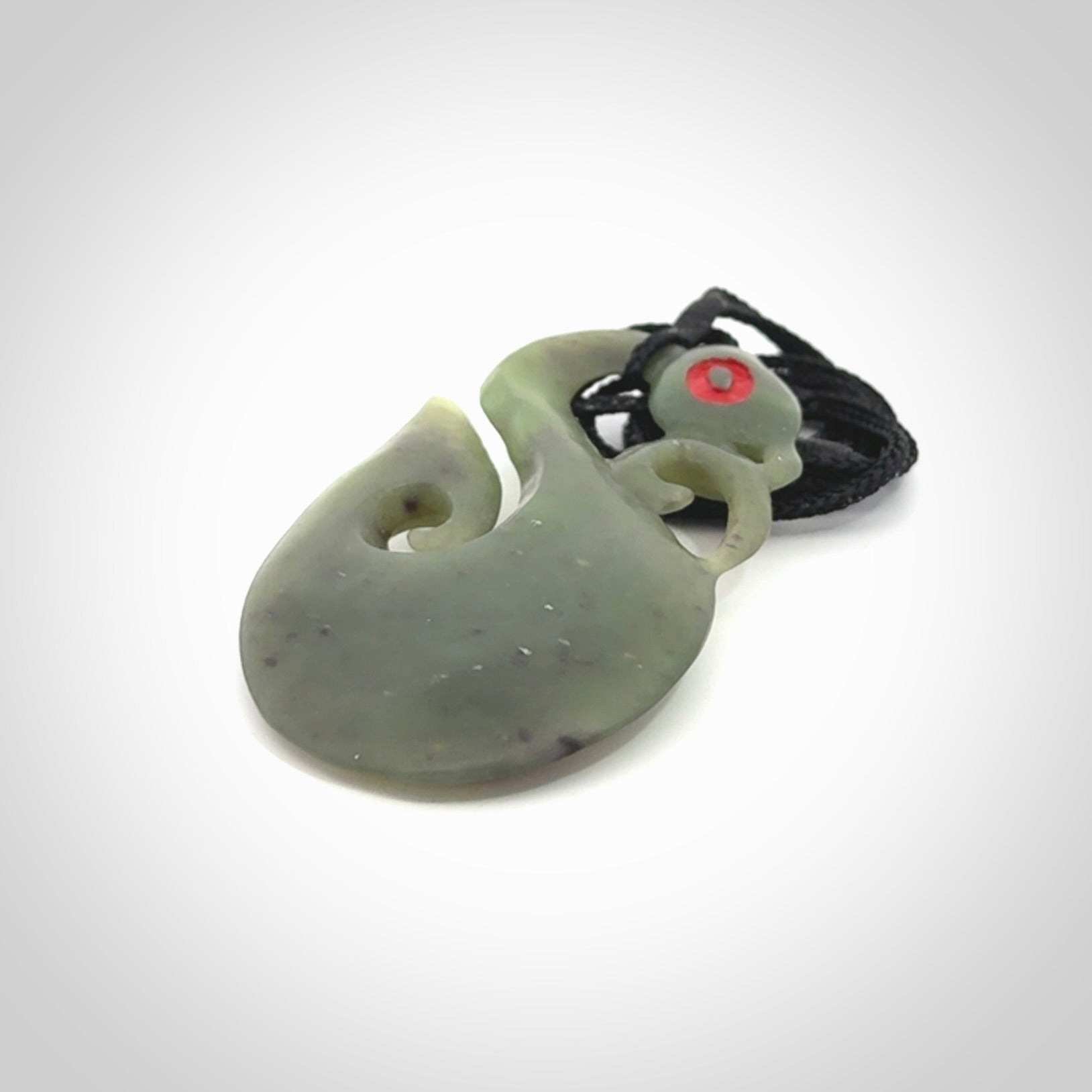 This picture shows a traditional manaia with hook pendant carved in New Zealand Jade.